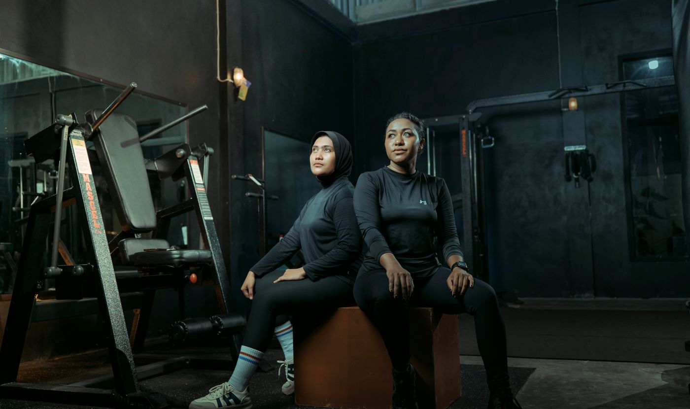 Two people in gym kit — sweat and friction from workouts are common back acne (bacne) triggers