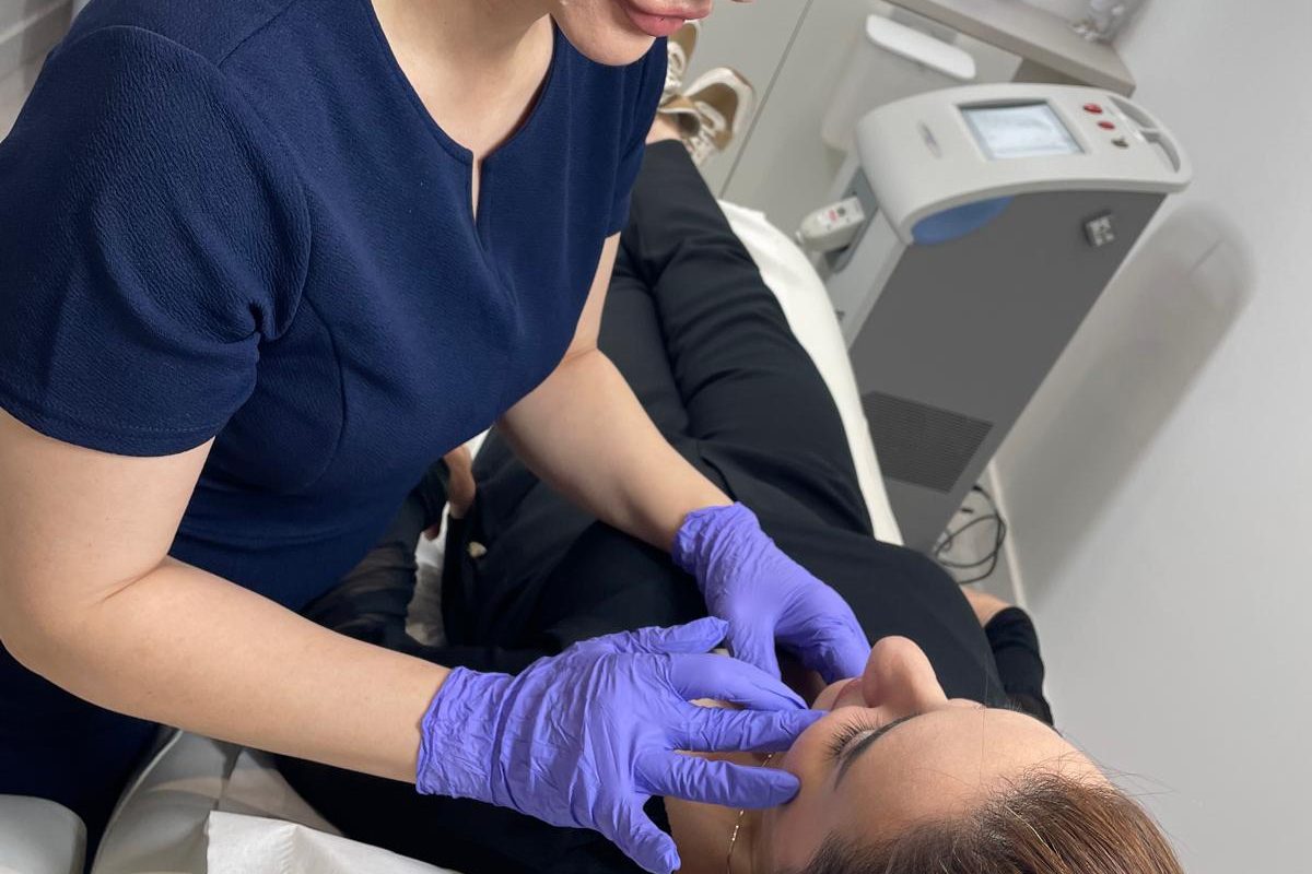 Practitioner assessing a client’s lips before choosing between 0.5ml and 1ml of lip filler — Bury clinic near Manchester